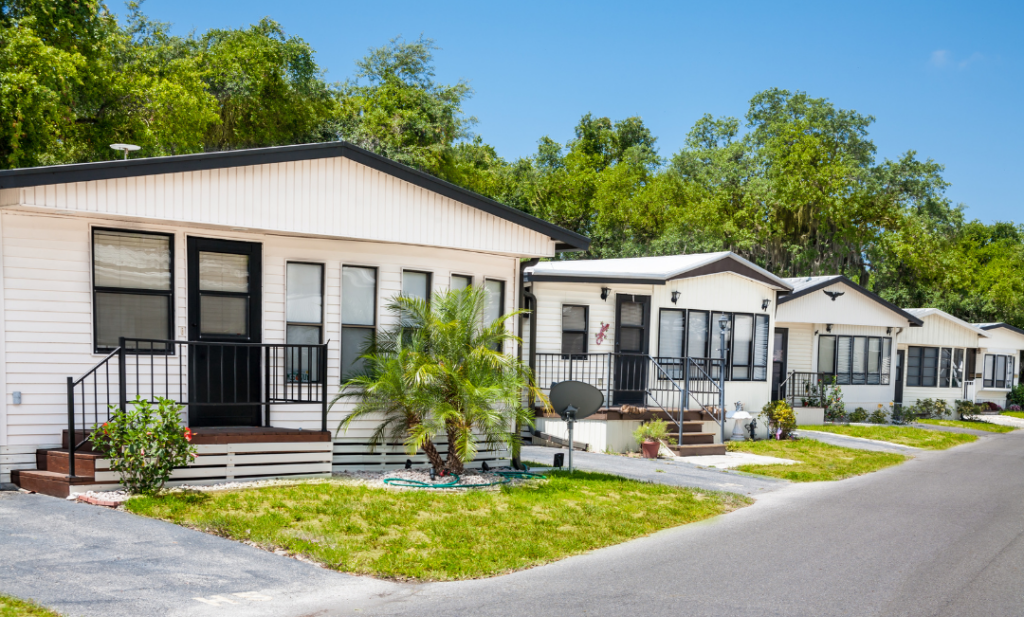 Mobile homes nestled in green scenery, in a well-maintained mobile home park.