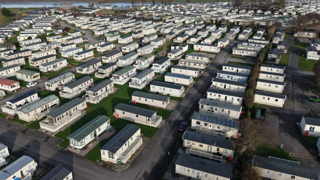 Aerial view of a large caravan park with rows of mobile homes set in a rural landscape