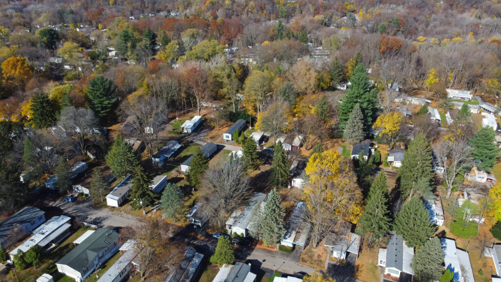 Large master planned mobile home trailer park with high density of prefabricated modular houses and colorful autumn leaves in Rochester, Upstate New York, US