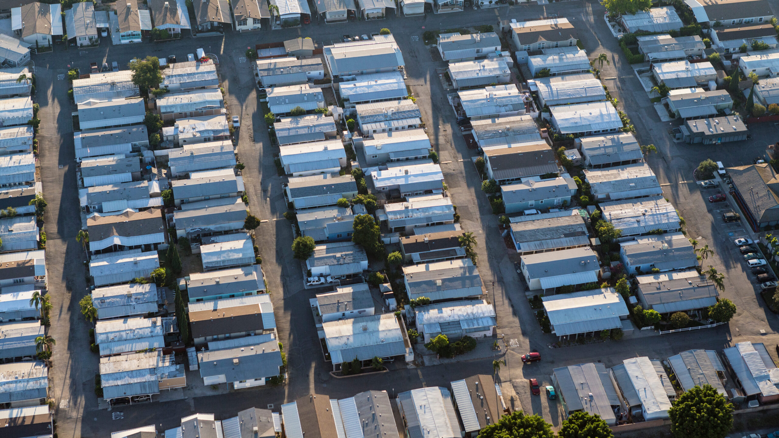 Aerial view of generic older mobile home rooftops in the southwest United States.